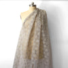 EOS Fabrics shimmering snowflake tulle in smoke gray with metallic gold accents draped on a dress form