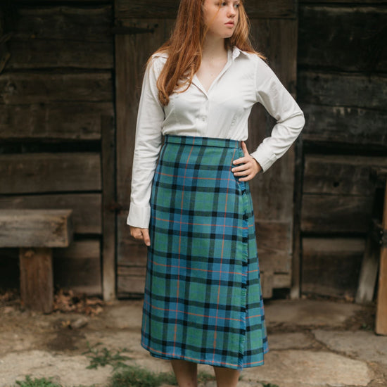Photo of a young woman standing outdoors wearing the kilt skirt.