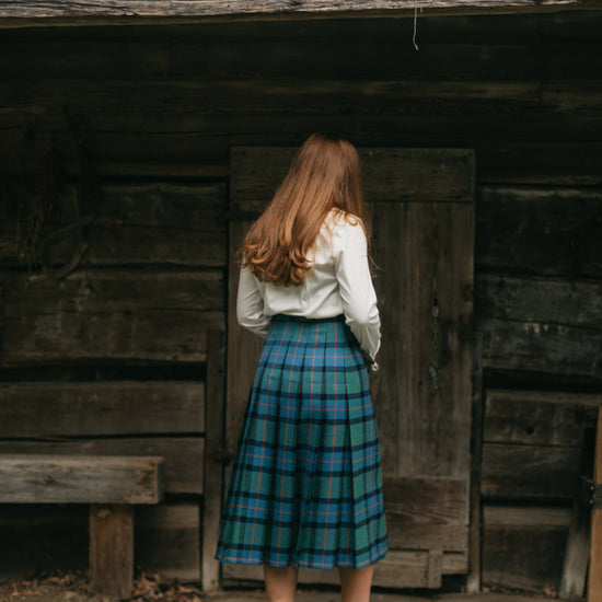 Photo of the back view of the kilt skirt on young woman walking.