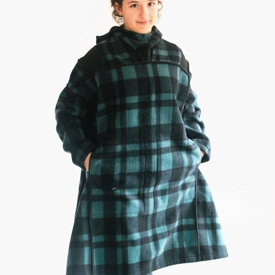Photo of young woman standing with hands in pockets of oversized fleece Siberian Parka.