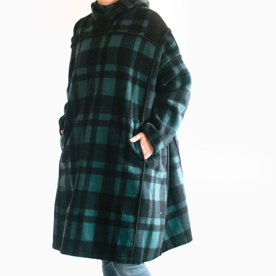 Photo of young woman wearing parka.  Model is slightly turned to show pocket set into front panel seam.