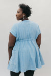 Back view of young African American woman with head looking over her shoulder wearing the women's Ghanaian Smock.