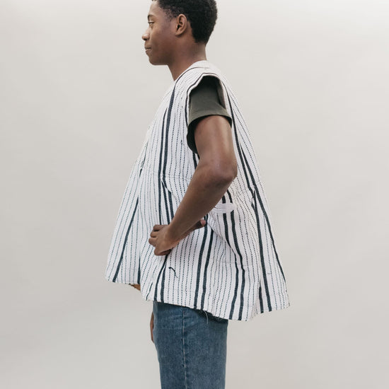 side view of Young African American man standing in front of a white studio backdrop wearing the men's Ghanaian Smock