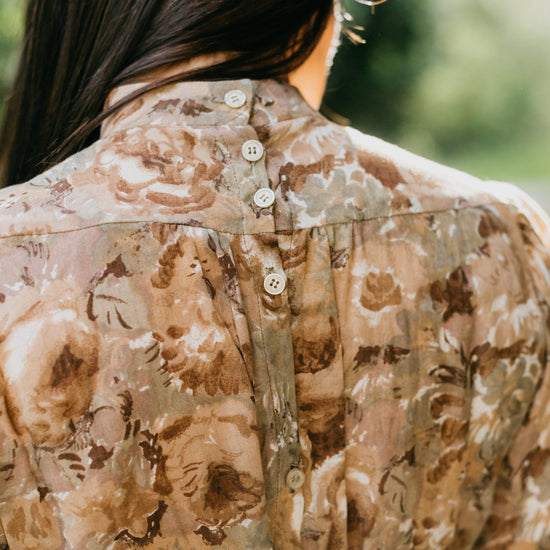 close up back view of brunette woman wearing 205 Gibson Girl Blouse, back fastened with tiny buttons.