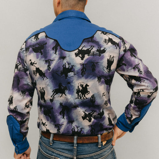 Back view of man standing in front of a white studio backdrop wearing 212 Five Frontier Shirt with decorative yoke in the back.
