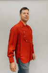 Man standing slightly turned to the side in front of a white studio backdrop wearing 212 Five Frontier Shirts View C with buttoned front bib.