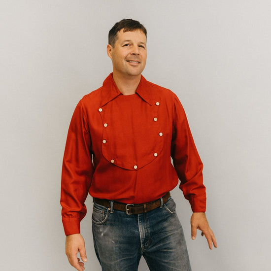Man standing in front of a white studio backdrop wearing 212 Five Frontier Shirts View C with a buttoned bib shape in the front.