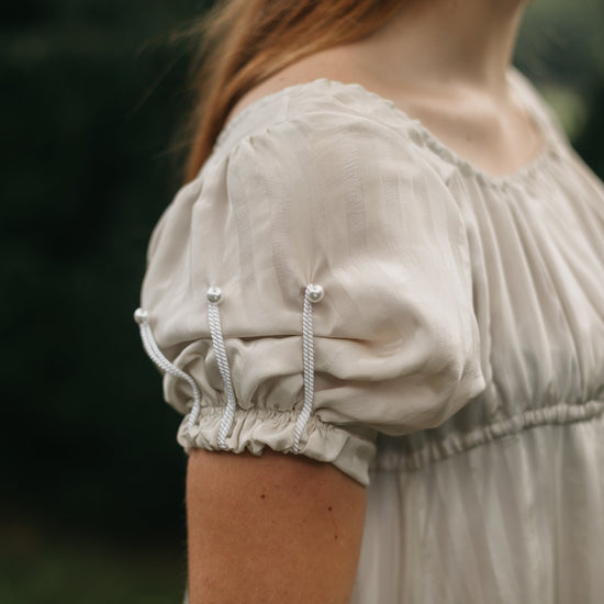 Close up of the sleeve of 215 Empire Dress with short puffed sleeves with cord detailing.
