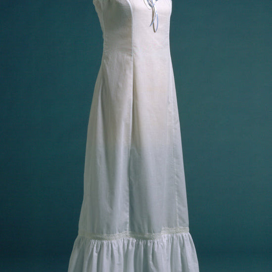 white princess slip on  a dress form.