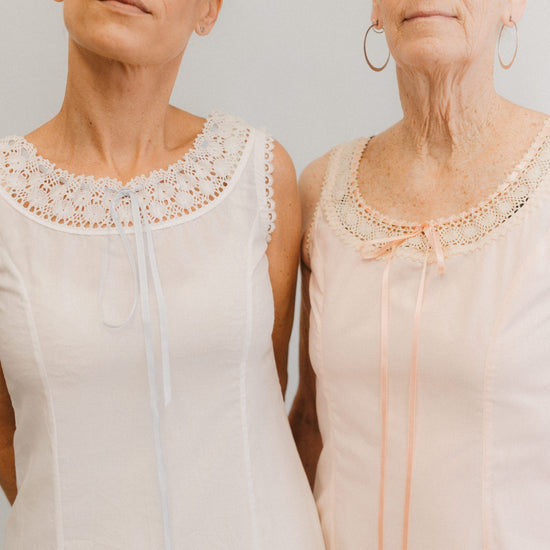 Close up of the top of two slips with lace at the necklines.