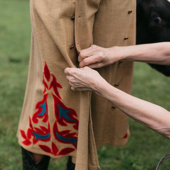 Close up view of a woman buttoning the buttons of another woman wearing the 231 Big Sky Riding Skirt.