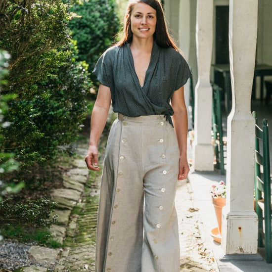 Young brunette white woman walking surrounded by greenery wearing the 231 Big Sky Riding skirt buttoned giving the effect of pants.