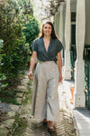 Young brunette white woman walking surrounded by greenery wearing the 231 Big Sky Riding skirt buttoned giving the effect of pants.