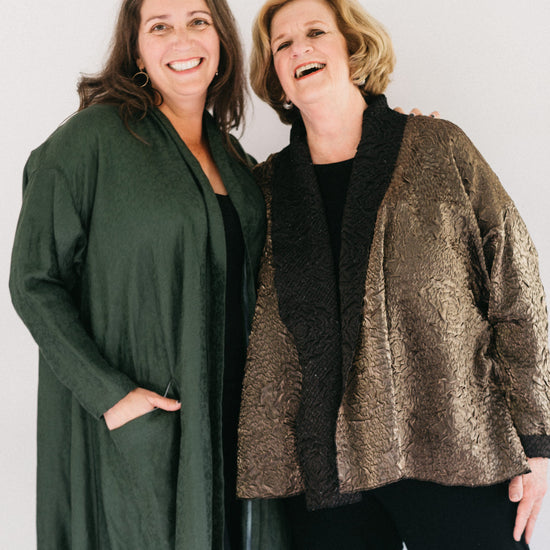 Two women  smiling standing next to each other wearing the 254 Swing Coat one long and the other hip length.
