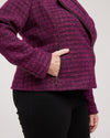 Person wearing a purple textured jacket with a plain background. This biker jacket is the Canton Moto Jacket sewing pattern from Cashmerette.