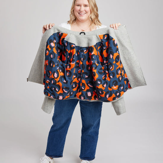 Person holding a colorful patterned jacket against a plain background. This biker jacket is the Canton Moto Jacket sewing pattern from Cashmerette.