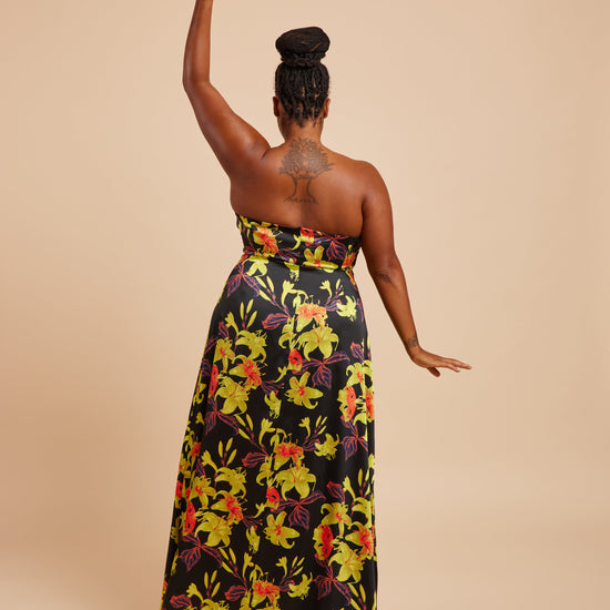 Woman wearing a strapless floral dress with a beige background. This dress is the Ellington Strapless Dress sewing pattern from Cashmerette.