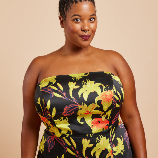 Woman wearing a strapless dress with a floral pattern on a beige background. This dress is the Ellington Strapless Dress sewing pattern from Cashmerette.