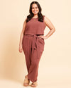 Woman wearing a brown sleeveless top and pants on a beige background. These pants are the Everett Pants & Shorts sewing pattern from Cashmerette.