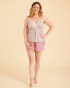Woman wearing a sleeveless top and shorts on a beige background. This is the Fiske Sleepwear Set sewing pattern from Cashmerette.