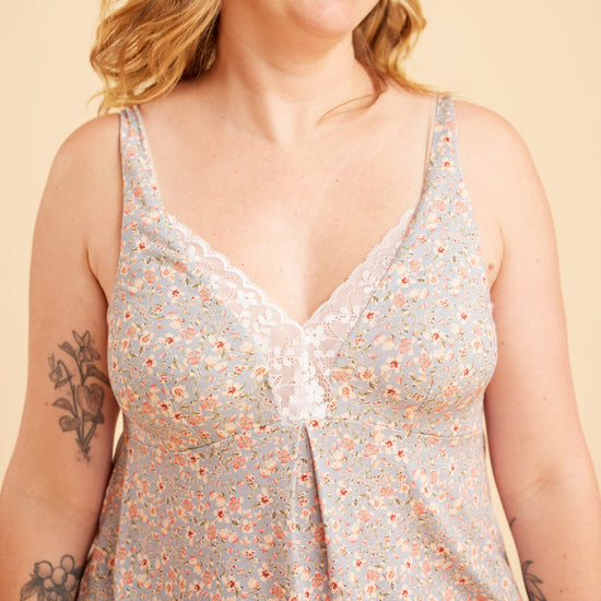 Woman wearing a floral sleeveless top against a beige background. This is the Fiske Sleepwear Set sewing pattern from Cashmerette.
