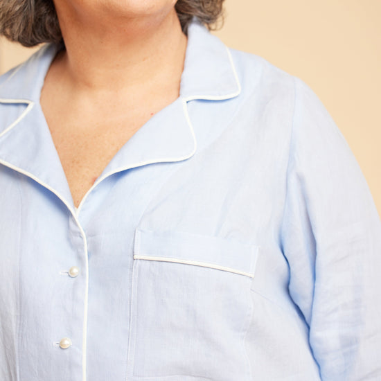 Light blue shirt worn by a person on a beige background. This is the Fiske Sleepwear Set sewing pattern from Cashmerette.
