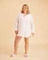 Woman wearing a light pink nightshirt on a beige background. This is the Fiske Sleepwear Set sewing pattern from Cashmerette.