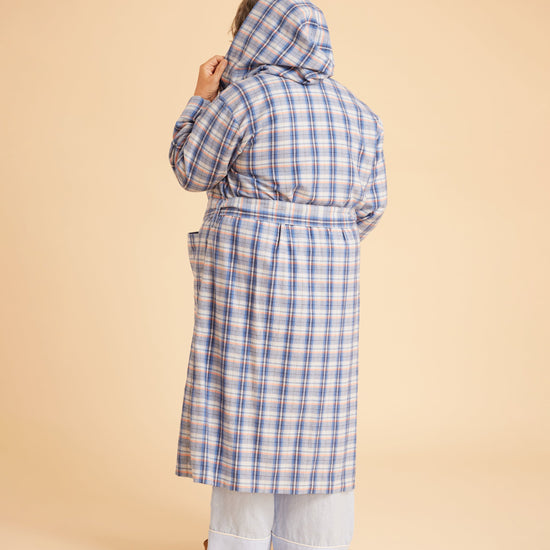 Person wearing a blue plaid coat on a beige background. This is the Fiske Sleepwear Set sewing pattern from Cashmerette.