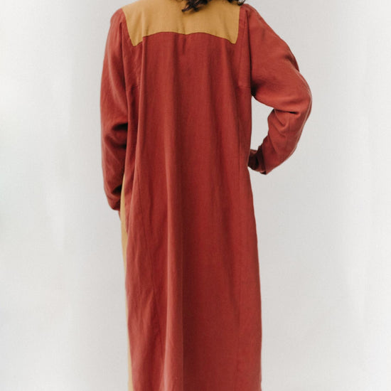Back view of Gaza Dress that is red with mustard yellow top yoke.