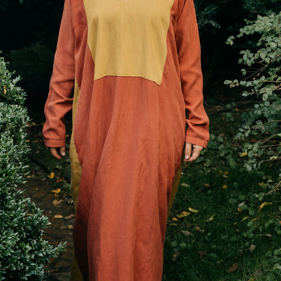 Front view of Gaza Dress, floor length red dress with large mustard yellow yoke.