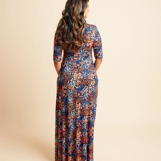 Woman wearing a floral dress on a beige background. This is the Grafton Dress, Top & Skirt sewing pattern from Cashmrette.