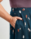 Person wearing a dark green skirt with abstract pattern, holding their hand in their pocket.. This is the Holyoke Maxi Dress & Skirt sewing pattern from Cashmerette.