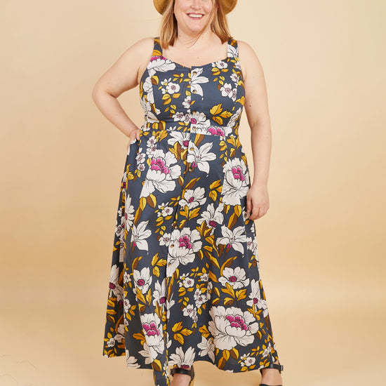 Woman wearing a floral dress with a beige background. This is the Holyoke Maxi Dress & Skirt sewing pattern from Cashmerette.