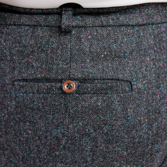 Close-up of a gray textured fabric with a button on a white background. These pants are the Meriam Trousers sewing pattern from Cashmerette.