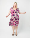 Woman wearing a floral dress on a white background. This dress is the Turner Dress sewing pattern from Cashmerette.
