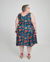 Woman wearing a blue floral dress on a white background. This dress is the Upton Dress & Skirt sewing pattern from Cashmerette.