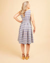 Woman wearing a blue and white striped dress against a beige background. This dress is the Upton Dress & Skirt sewing pattern from Cashmerette.