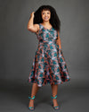 Woman wearing a floral dress against a gray background. This dress is the Upton Dress & Skirt sewing pattern from Cashmerette.
