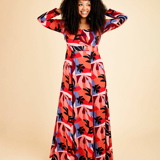Woman wearing a colorful patterned dress on a beige background. This dress is the Upton Dress & Skirt sewing pattern from Cashmerette.